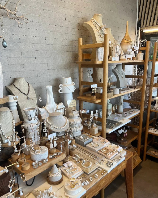 Necklaces and earrings arranged on wooden displays inside Nakamol at Patong Signature
